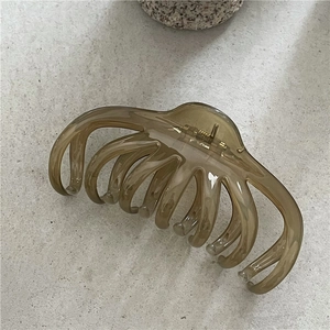 Detailed macro view of large amber resin hair claw clip showing glossy jelly texture