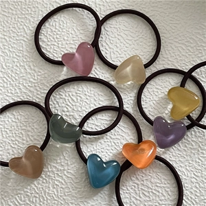 Detailed view of colorful resin heart charms on flexible black elastic hair ties set