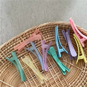 Barrettes à cheveux colorées en plastique disposées dans un panier tressé