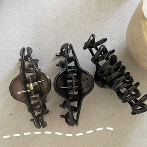 Flat lay of three large elegant hair claws in translucent brown and glossy black finishes