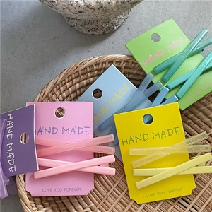 Gros plan de pinces à cheveux croisées colorées rose et jaune sur cartes faites main