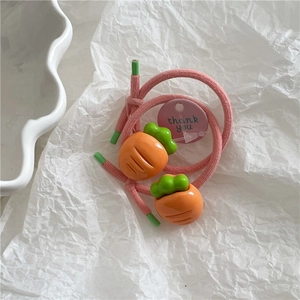 Close-up of pink elastic hair ties with cute orange carrot resin charms and gift tag
