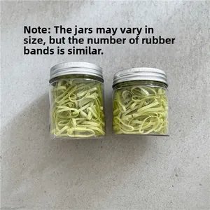 Detail view of small and large transparent jars containing green elastic hair ties