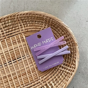 Lot de quatre barrettes à cheveux violettes mates et translucides sur carte de support