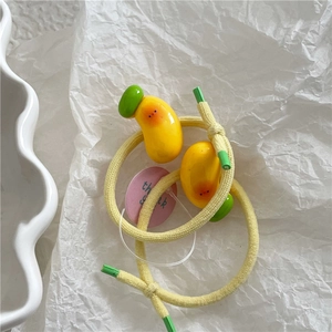 Detail of yellow knit hair ties with cute mango charms and a pink thank you tag