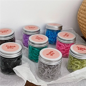 Colorful elastic hair bands set in transparent jars with thank you label on silver lids