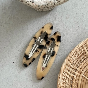 Detailed view of tortoiseshell pattern acetate hair clips with silver metal pressure clips
