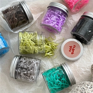 Colorful disposable elastic hair band set in clear plastic jars with silver screw lids