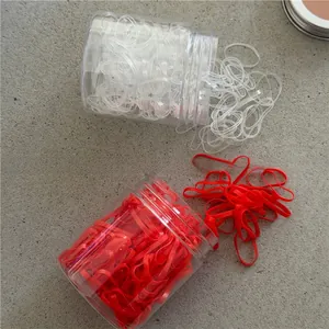 Detailed macro view of colorful high-elastic hair ties in transparent cylindrical containers