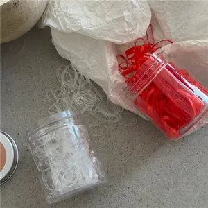 Close-up of colorful high-elasticity hair ties in a portable plastic storage jar