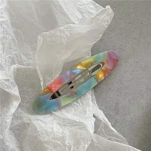 Detail showing marble texture acetate hair clip with pink and purple pastel tones