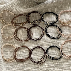 Détail d'élastiques à cheveux avec perles et strass sur des bandes extensibles multi-fils
