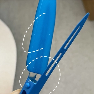 Detailed macro view of the internal spring structure and matte blue finish on hair clip