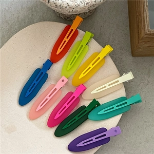 Detailed top view of ten colorful matte jelly waterdrop hair clips on a stone tray