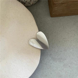 Dettaglio ravvicinato di un fermaglio per capelli in metallo lucido a forma di cuore
