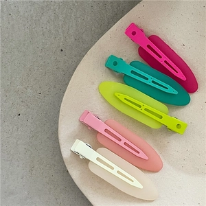 Five colorful macaron matte hair clips in a leaf shape on a marble tray for summer styling