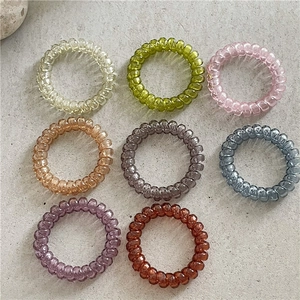 Lot de 8 chouchous spirales translucides aux couleurs pastel sur une surface en pierre