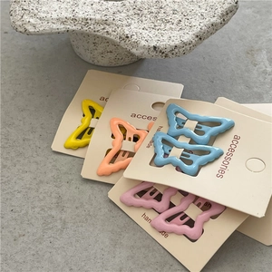Pastel cream-colored butterfly hair clips set on display card with matte metal finish