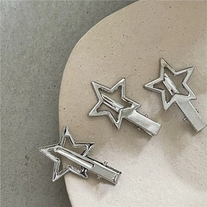 Détail macro de pinces à cheveux étoiles argentées Y2K avec textures métalliques