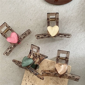Set of four heart-shaped hair claw clips in translucent brown resin with matte accents