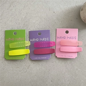Détail de pinces à cheveux géométriques aux textures mates et gel de couleurs vives