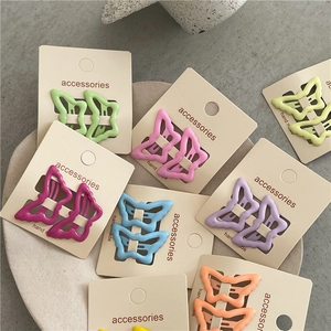 Detail of colorful butterfly hair clips in candy tones on white card packaging