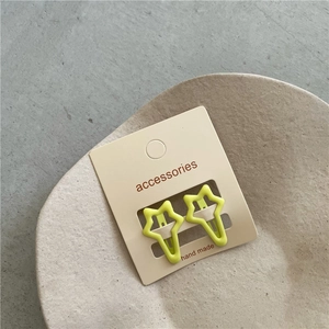 Close-up of star-shaped neon green hair clips set on handmade display card and ceramic plate