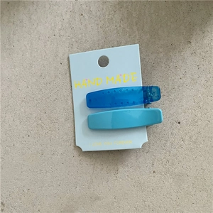 Détail d'un lot de barrettes bleues comprenant une pince translucide et une opaque