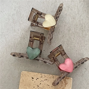 Detail of heart-shaped hair claw clips set with tortoise shell pattern and cream decorations