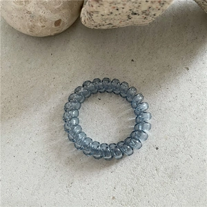 Gros plan détaillé d'un élastique spirale bleu translucide sur une surface en pierre