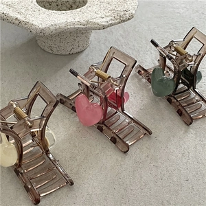 Detailed view of heart-shaped hair claw clips made of translucent resin and metal spring