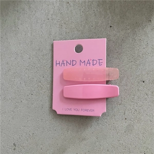 Détail d'un lot de barrettes à cheveux roses mates et brillantes sur carte de support
