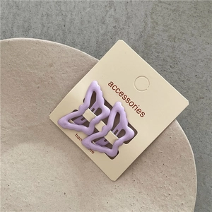 Detail of lavender butterfly hair clips in matte finish on premium retail card