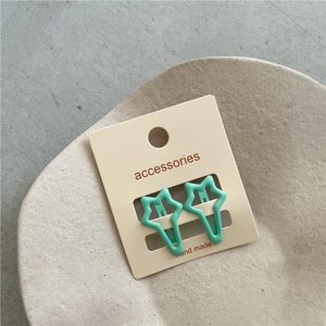 Detail of mint green star-shaped hair clips on a presentation card in a minimalist tray