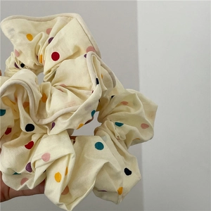 Détail du chouchou en tissu blanc crème avec pois colorés et volants texturés doux