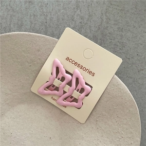 Detail of sweet butterfly hair clips in soft pink matte plastic on display card