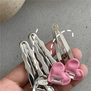 Détail de barrettes à cheveux cœurs roses avec cristaux et pinces argentées