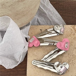 Gros plan de barrettes à cheveux cœur en strass rose sur fond de pierre naturelle