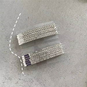 Close-up of a 12-piece silver alloy hair clip set with sparkling rhinestones on grey surface