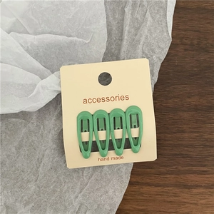 Set of four glossy bean green drop hair clips displayed on a handmade accessories card