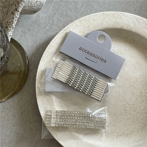 Detail view of silver rhinestone twist hair clip set on a white ceramic plate