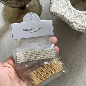 Silver rhinestone and spiral metal hair clip set for women displayed on stone surface