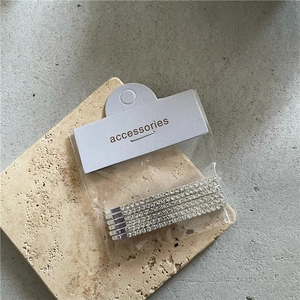 Detailed view of five silver rhinestone twist hair clips on a premium textured stone base
