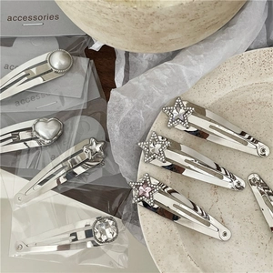 Set de pinzas BB de metal plateado con pedrería de estrella y perlas de corazón en bandeja