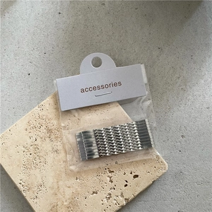 Silver twisted metal hair pins with rhinestones on a beige stone block background