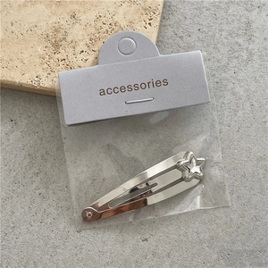 Primer plano de una pinza para el pelo de estrella plateada con strass sobre fondo gris