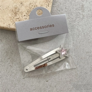Detalle de pinza para el pelo estrella con strass rosa y clip BB plata en tarjeta