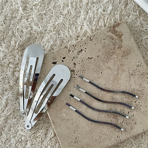 Set di fermagli BB in argento e forcine ondulate su un supporto in pietra naturale