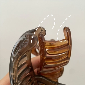 Macro d'une pince à cheveux ambre translucide avec ressort en métal et dents à rangées multiples