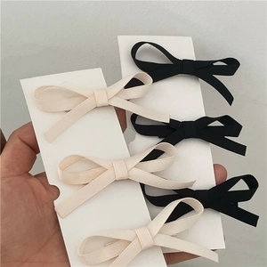 Five-piece bow hair clip set in black and cream beige fabric on display cards